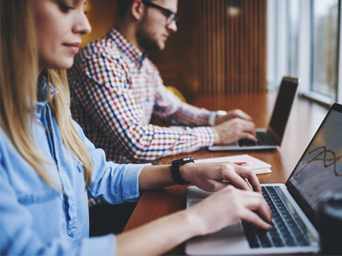 Employees working on laptops with Network Security in Alpharetta, Georgia